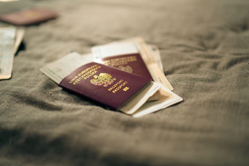 pexels-photo-32060712-32060712 A close-up of a Polish passport and travel documents placed on a fabric surface, symbolizing travel and identity.