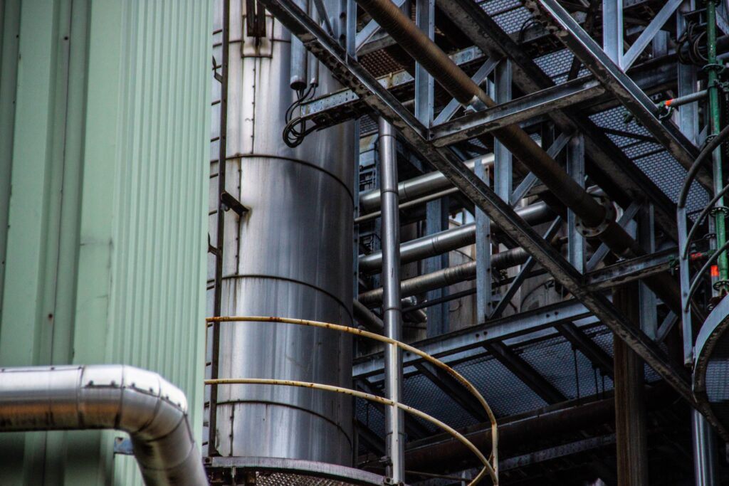 pexels-photo-6726394-6726394 Close-up of an industrial metal structure with pipes and steel framework seen outdoors.