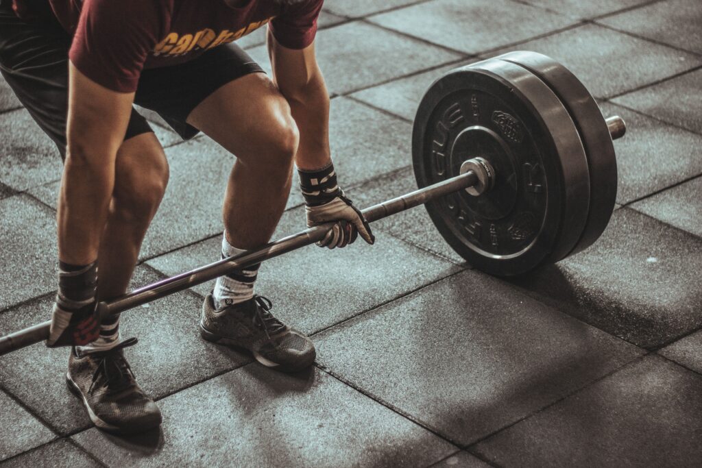pexels-photo-949126-949126 A focused weightlifter prepares to lift a heavy barbell in an indoor gym setting.